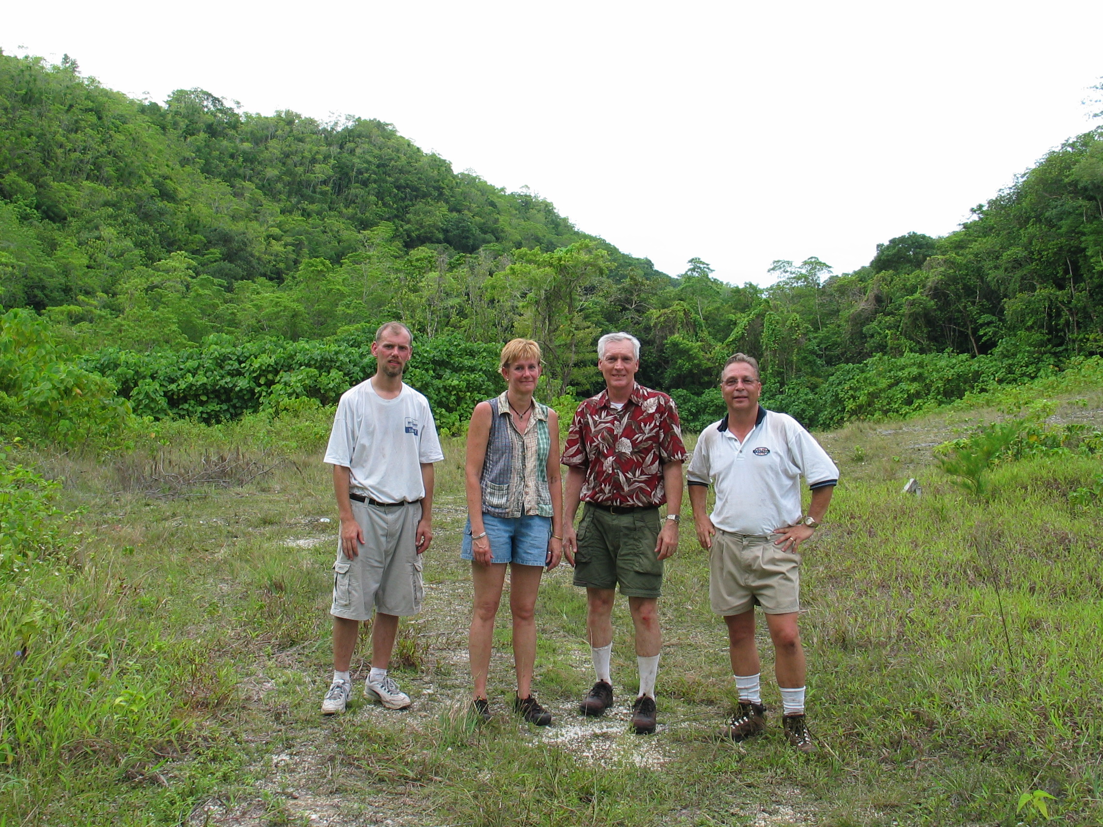 four people standing in grassy valley